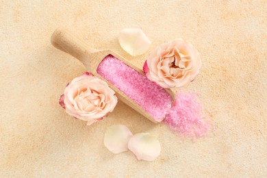 Pink sea salt and beautiful flowers on color textured table, flat lay