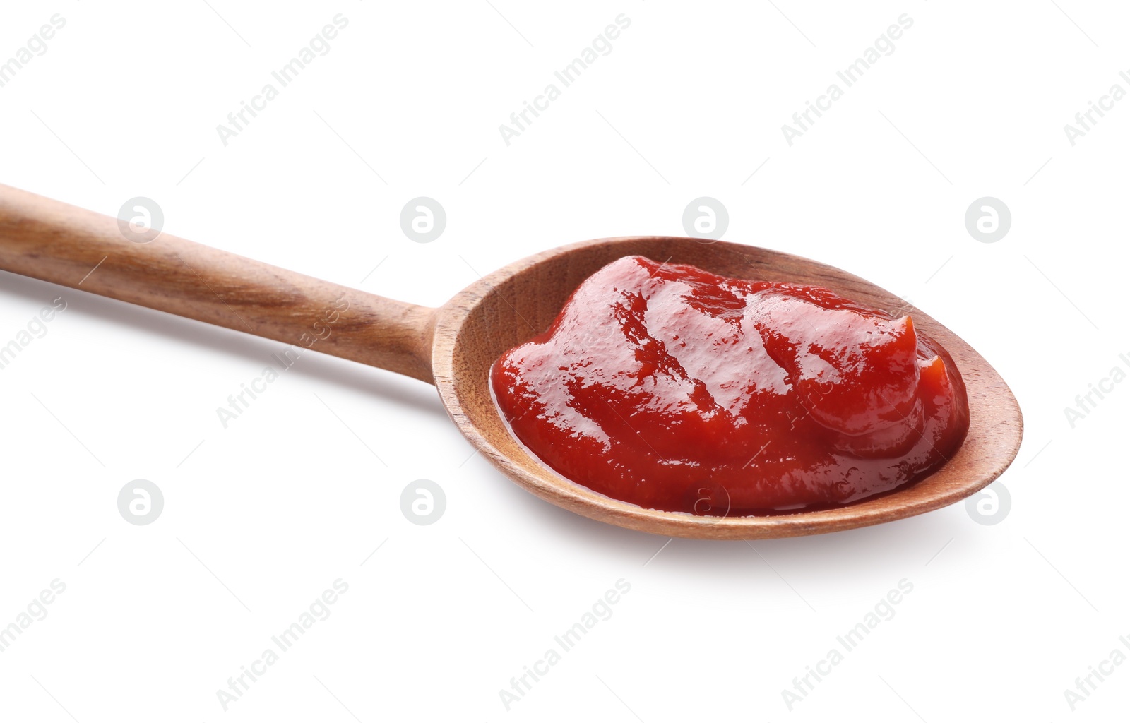 Photo of Tasty ketchup in wooden spoon isolated on white