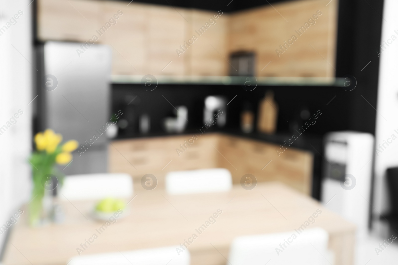 Photo of Blurred view of cozy modern kitchen interior with new furniture and appliances