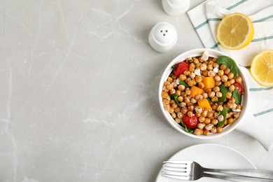 Photo of Delicious fresh chickpea salad served on light grey marble table, flat lay. Space for text