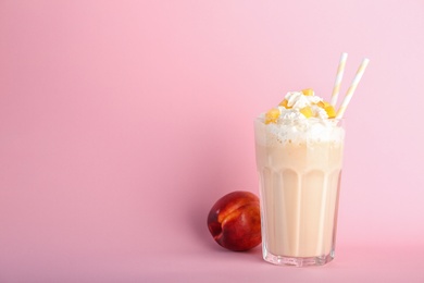Photo of Glass with delicious milk shake on color background