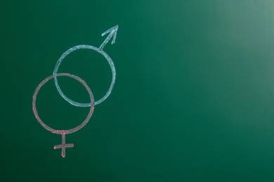 Photo of Gender symbols drawn on green chalkboard, space for text. Sex education