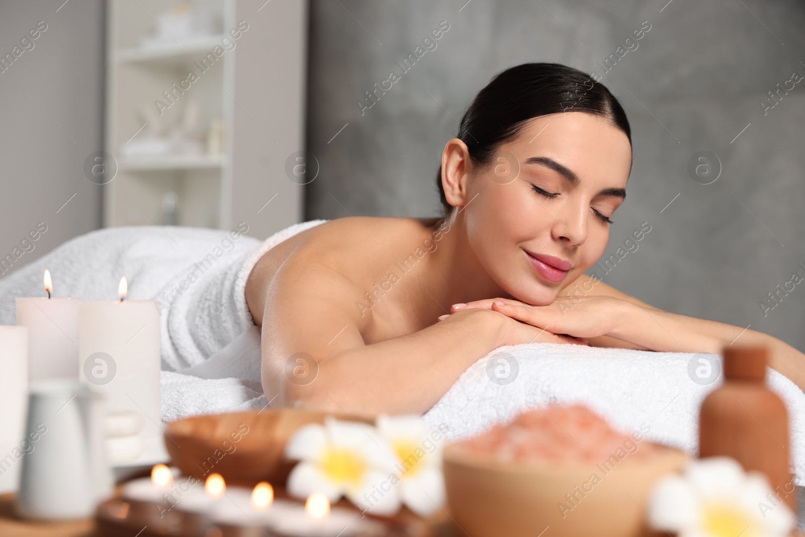 Photo of Beautiful woman relaxing on massage table in spa salon