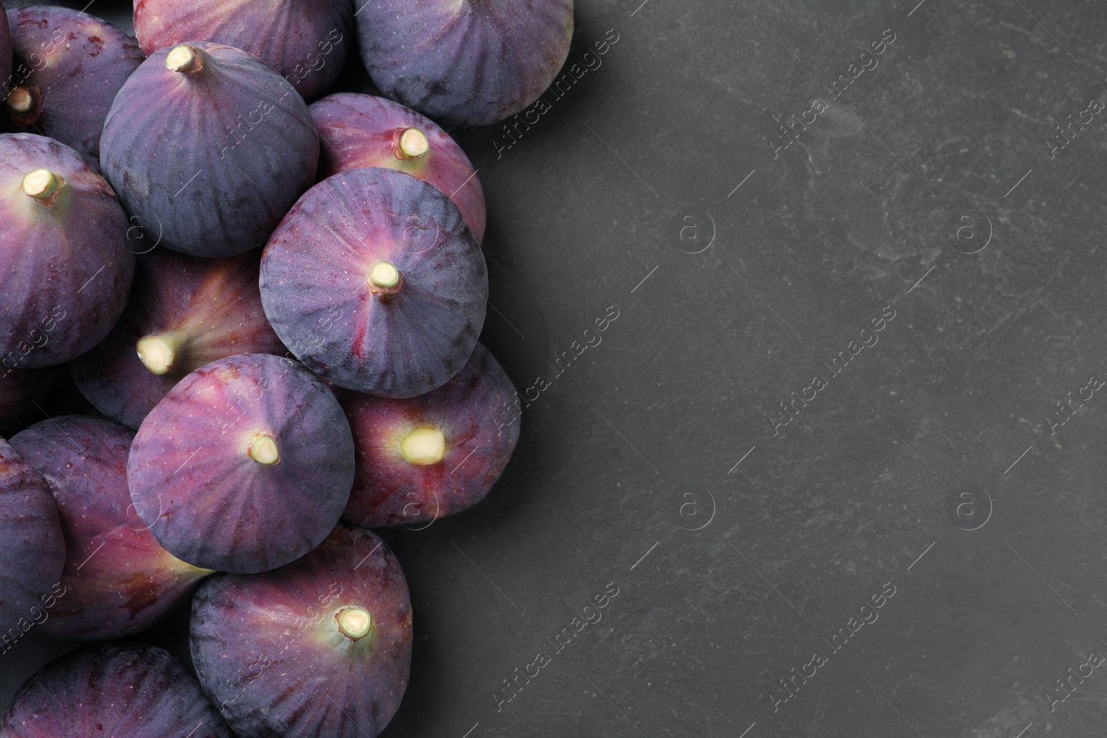 Photo of Fresh ripe figs on black table, flat lay. Space for text