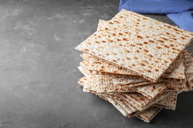 Photo of Stack of matzos on grey table. Space for text