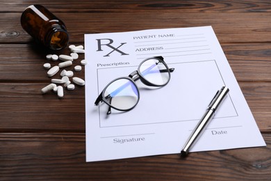 Photo of Medical prescription form with empty fields, glasses, pills and pen on wooden table