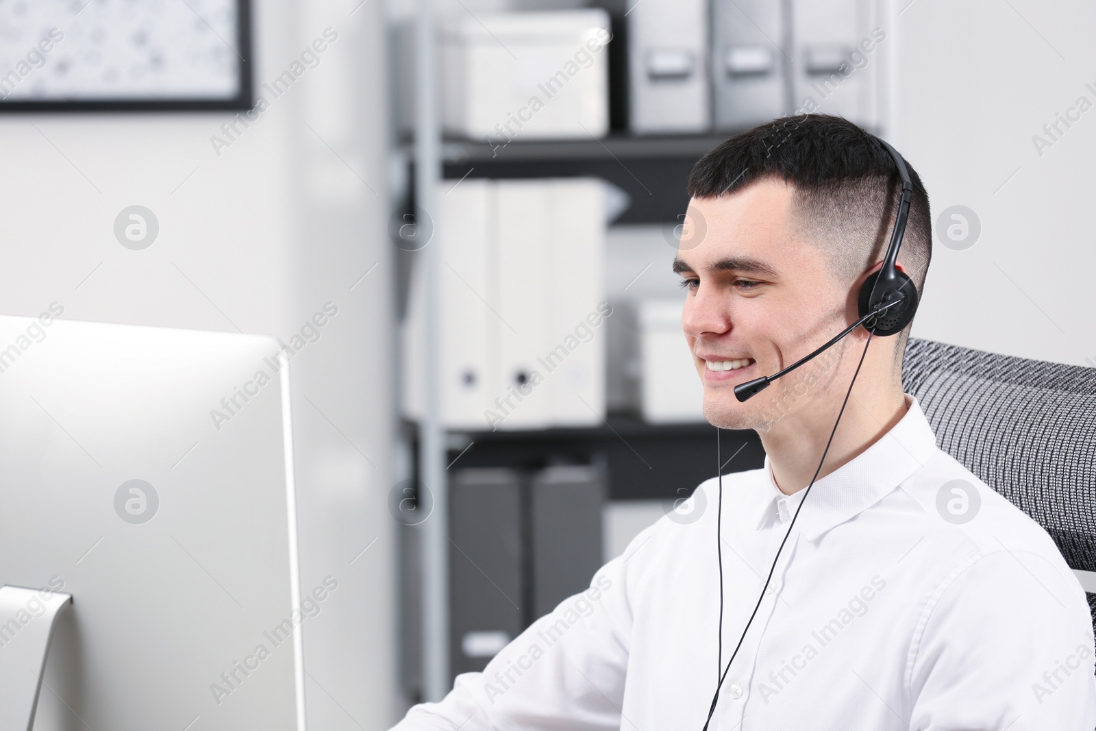 Photo of Hotline operator with headset working in office