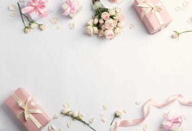 Flat lay composition with beautiful roses and gift boxes on white background. Space for text