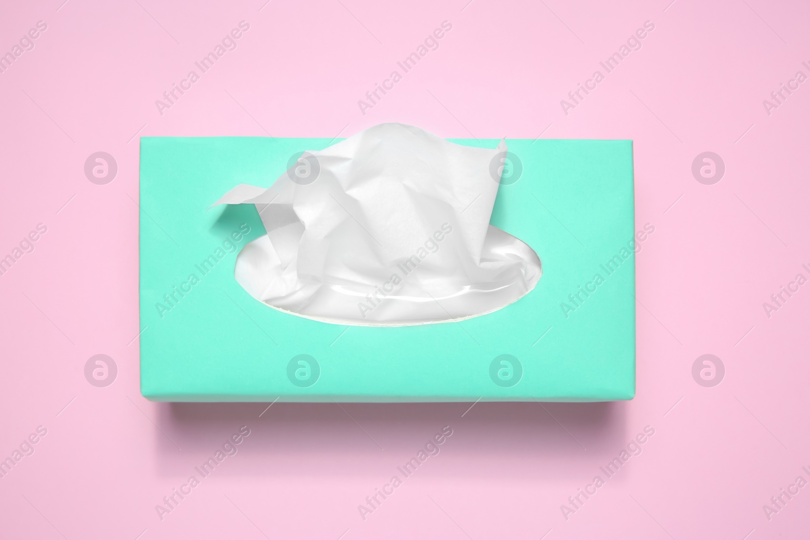 Photo of Box with paper tissues on pink background, top view