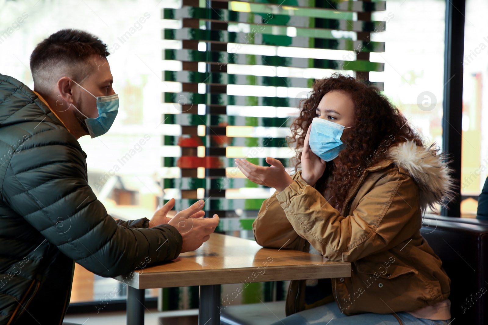 Photo of Couple with disposable masks in cafe. Virus protection