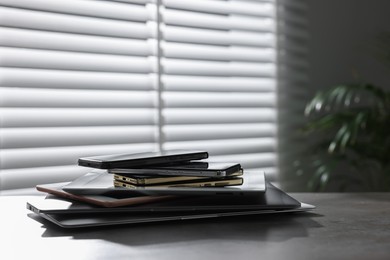 Photo of Many different modern gadgets on grey table indoors. Space for text