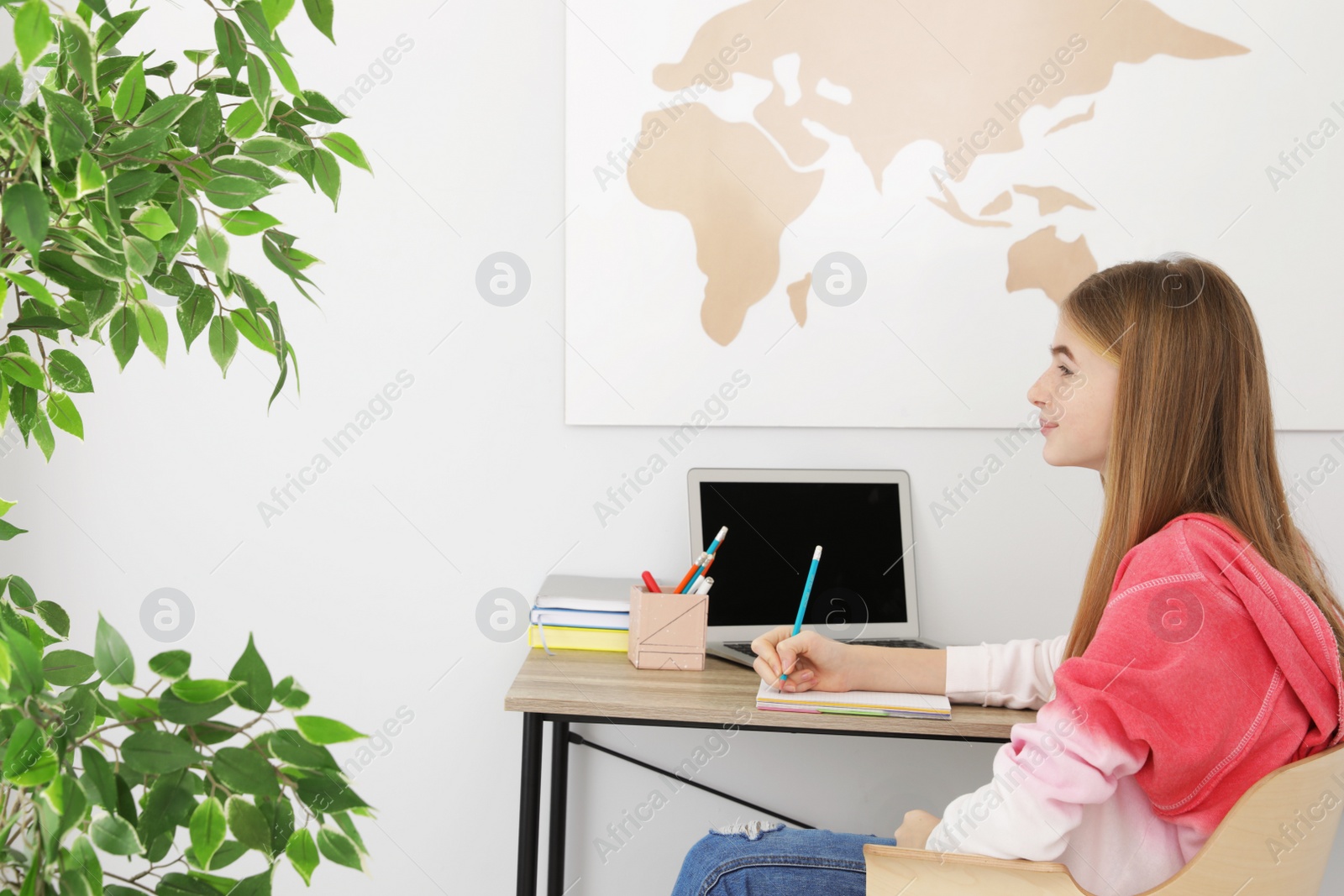 Photo of Teenager girl doing her homework at desk