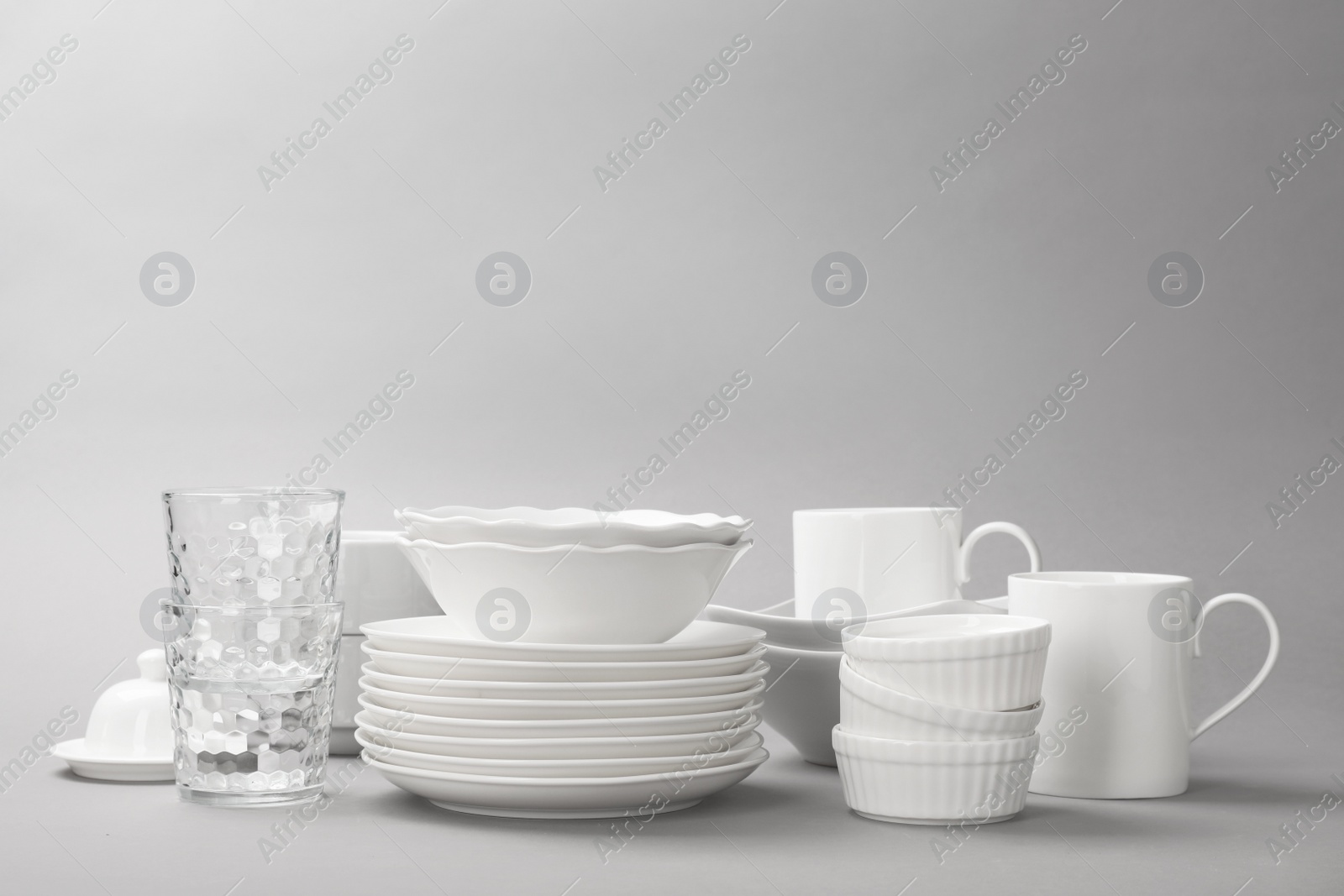 Photo of Set of clean tableware on grey background. Washing dishes