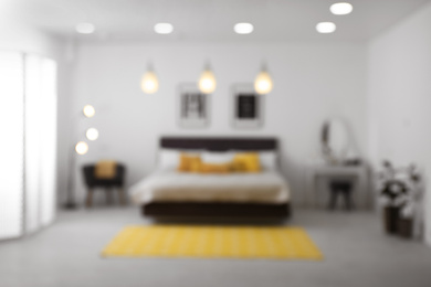 Blurred view of stylish room interior with comfortable bed