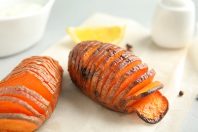 Photo of Delicious baked sweet potatoes on table, closeup