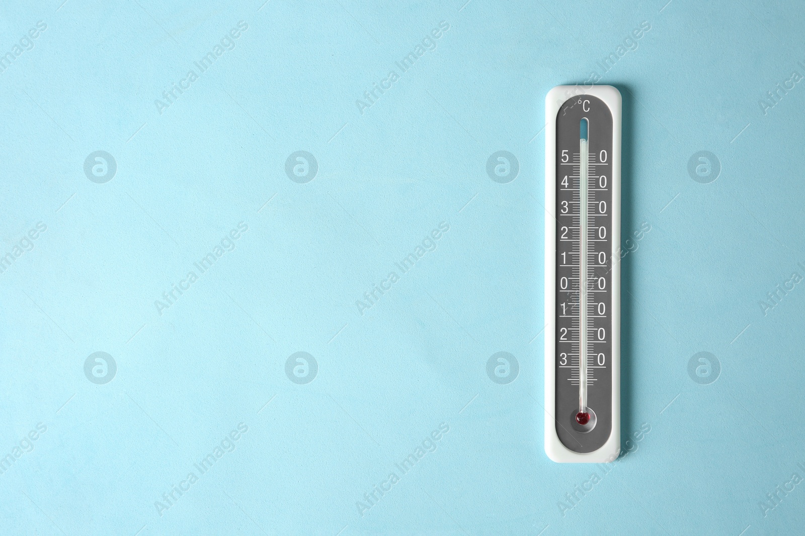 Photo of Weather thermometer on light blue background, top view. Space for text