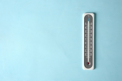 Photo of Weather thermometer on light blue background, top view. Space for text