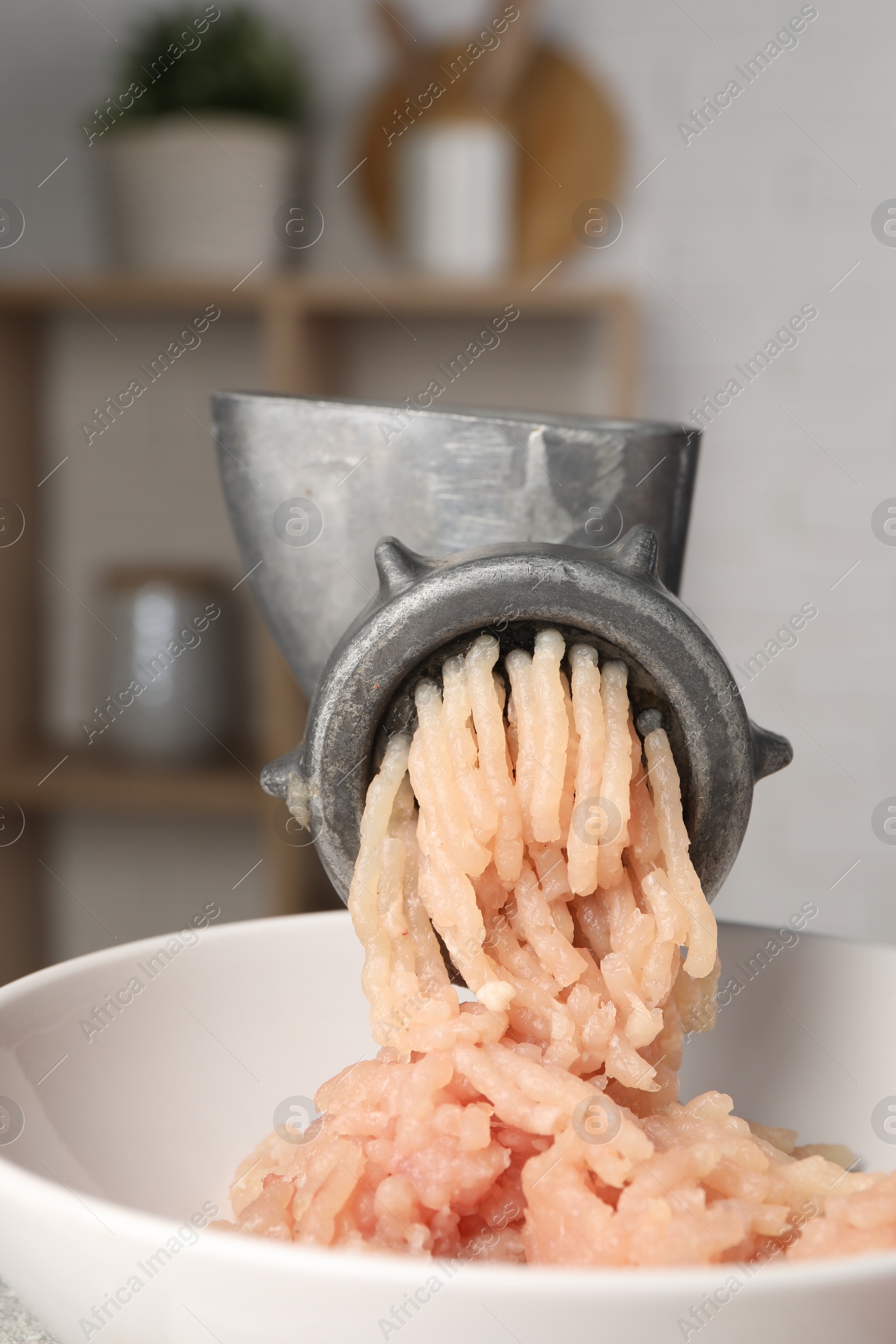 Photo of Metal meat grinder with chicken mince indoors, closeup