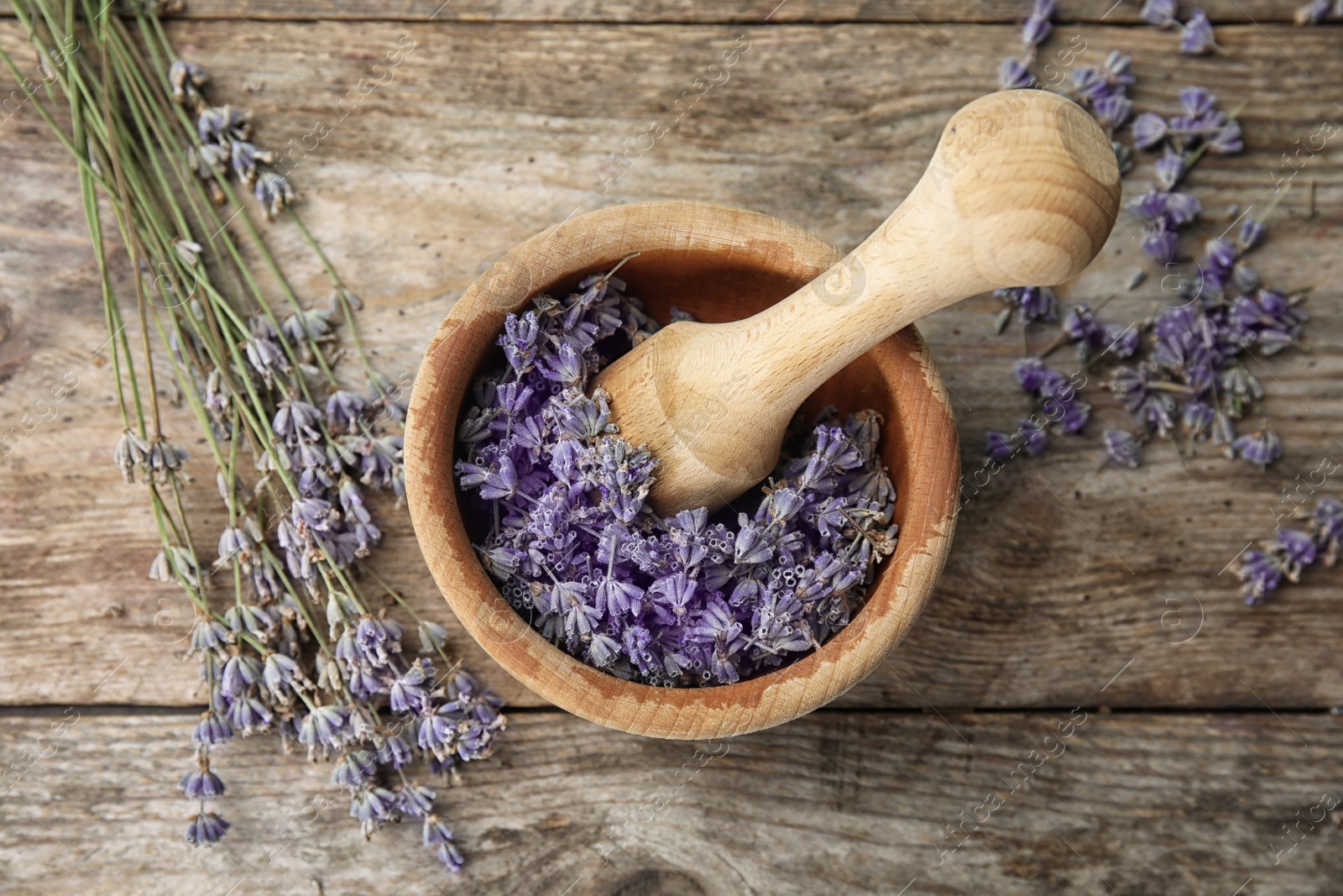 Photo of Mortar with lavender flowers on table, top view. Ingredient for natural cosmetic