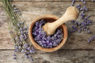 Photo of Mortar with lavender flowers on table, top view. Ingredient for natural cosmetic