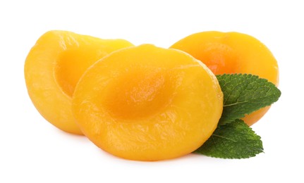 Sweet canned peach halves with mint isolated on white