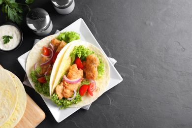 Photo of Delicious fish tacos served on dark grey table, flat lay with space for text
