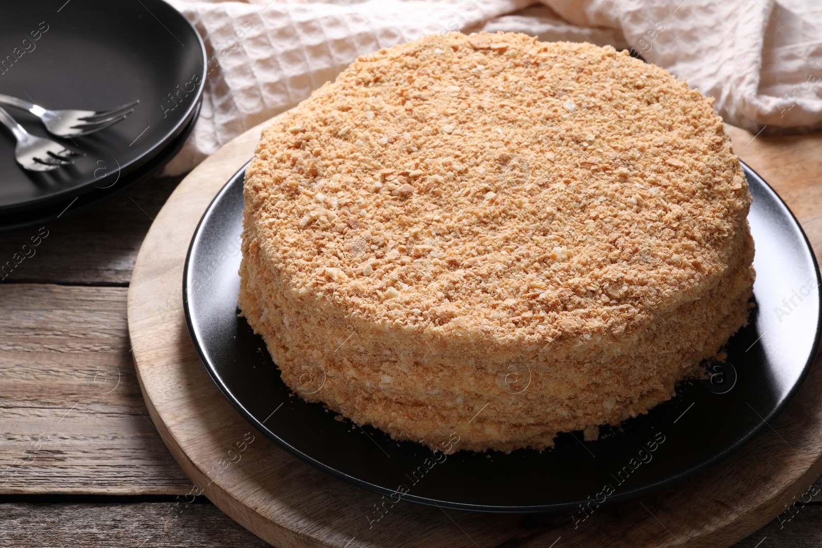 Photo of Delicious Napoleon cake on wooden table, closeup