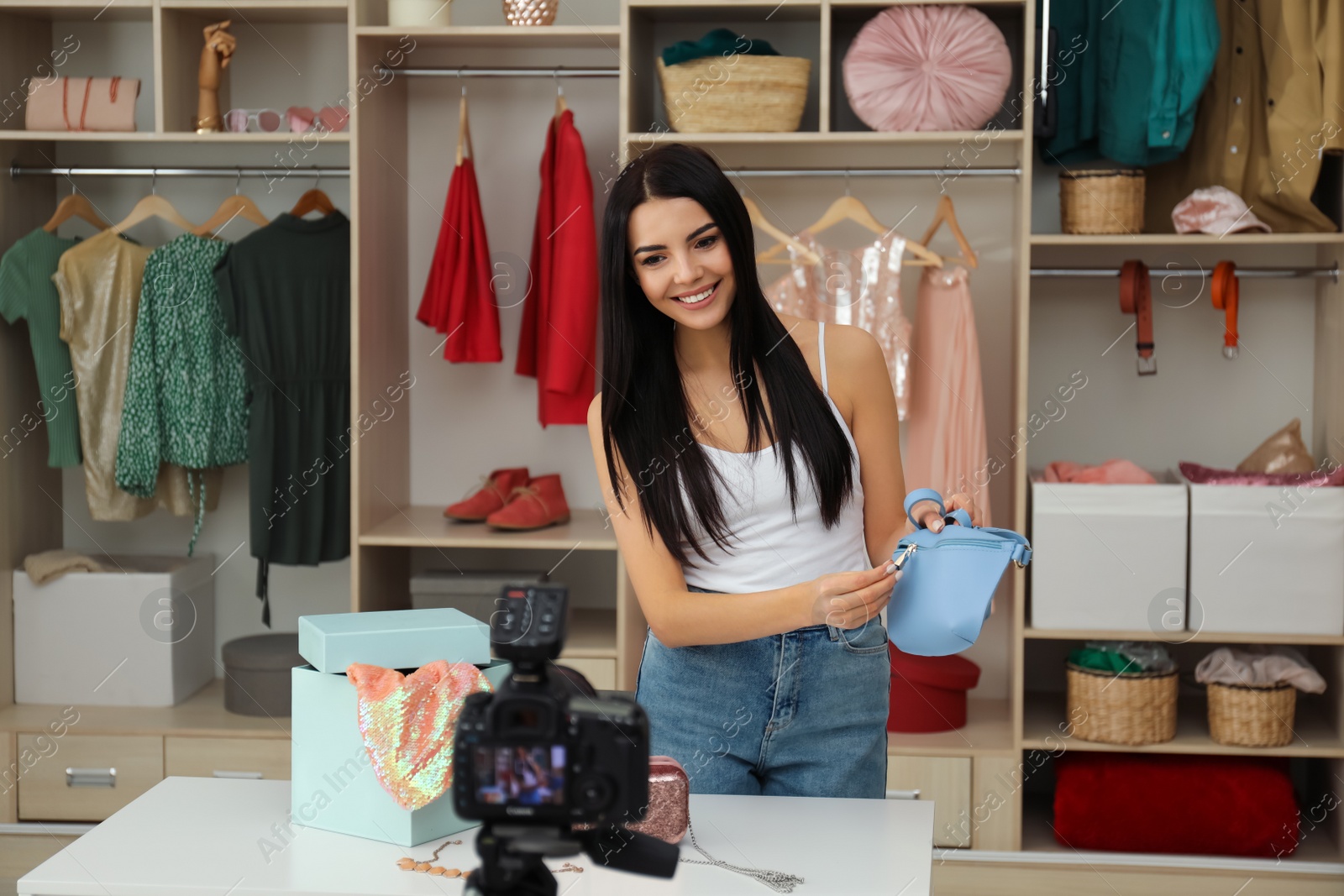 Photo of Fashion blogger recording new video at table indoors