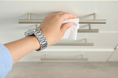 Woman using tissue paper to open drawer, closeup