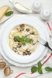 Photo of Delicious ravioli with mushrooms and cheese served on white wooden table, flat lay