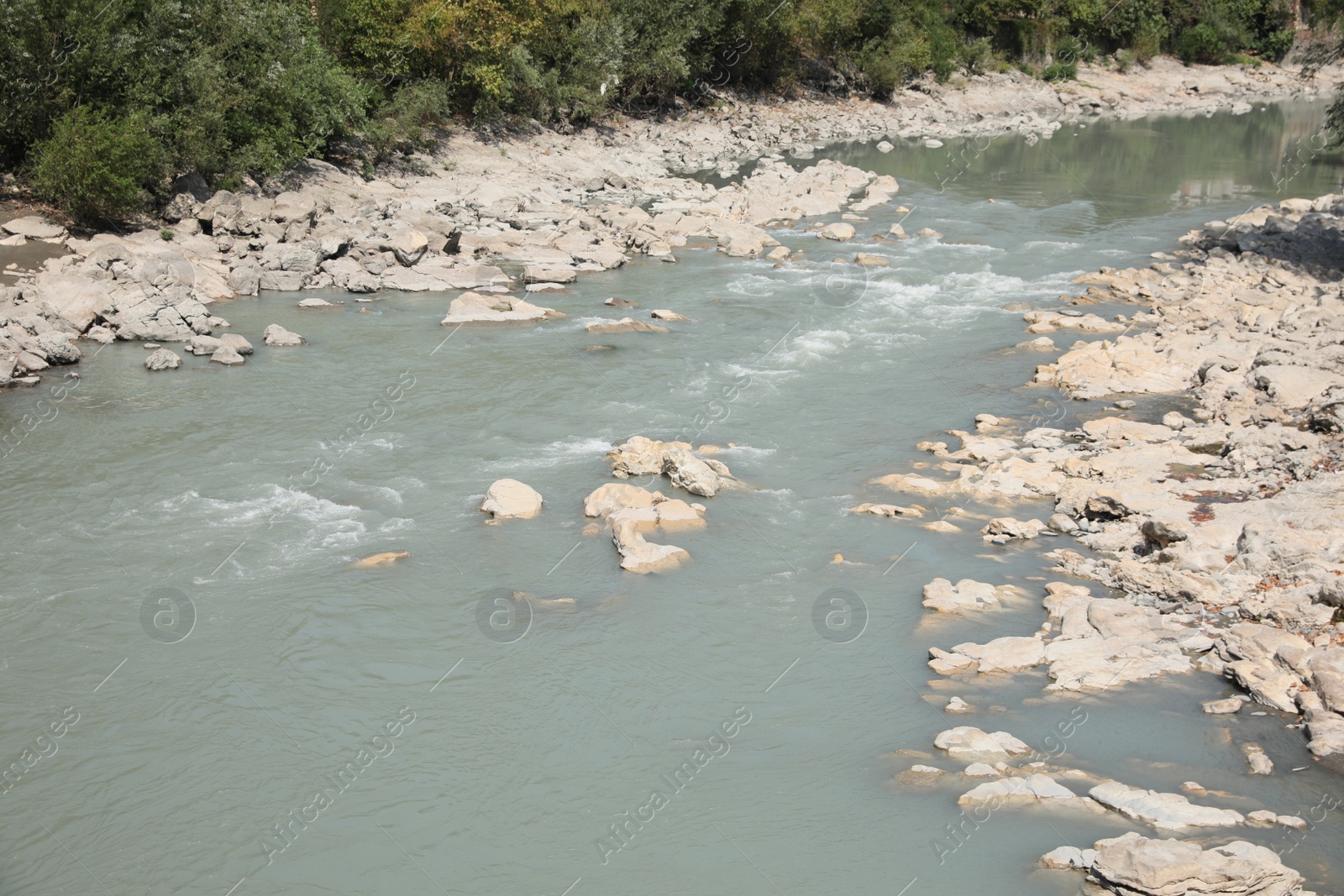 Photo of Picturesque view of clear river and rocks on sunny day