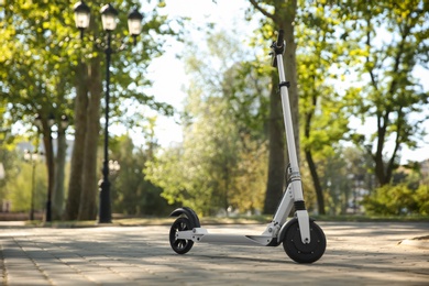 Photo of Modern electric kick scooter outdoors on sunny day
