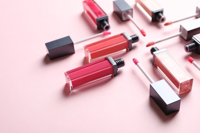 Photo of Composition of liquid lipsticks on color background