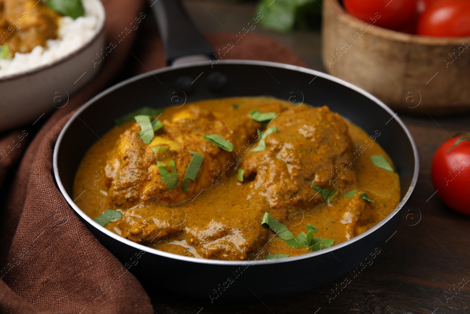 Photo of Delicious chicken with curry sauce served on wooden table, closeup