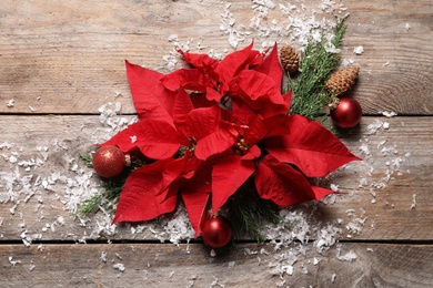 Flat lay composition with poinsettia on wooden background. Traditional Christmas flower