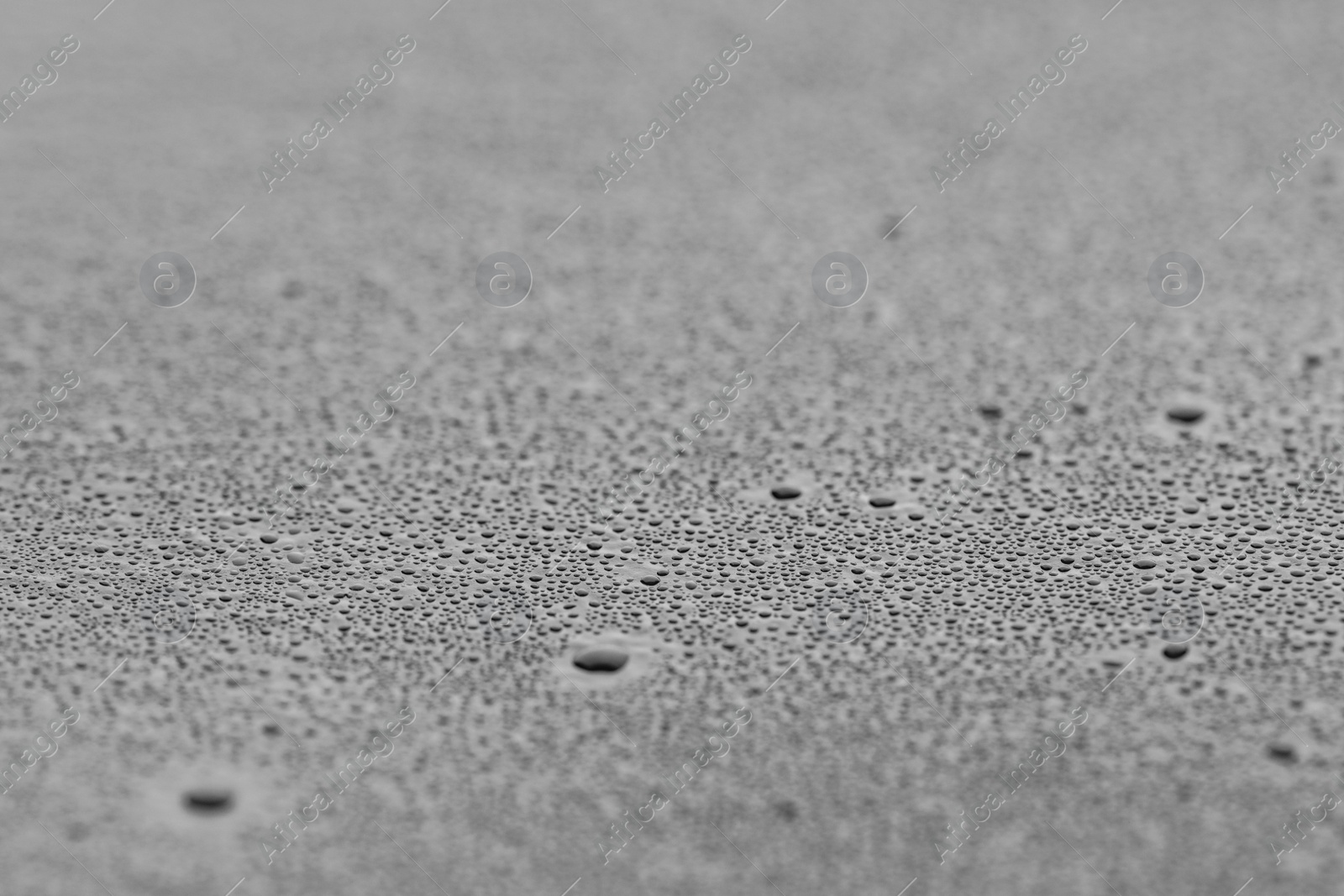 Photo of Water drops on grey surface, closeup view