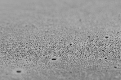 Water drops on grey surface, closeup view