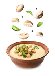 Fresh mushrooms, basil and peppercorns falling into bowl with homemade soup on white background