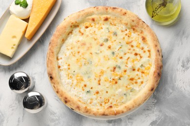 Photo of Delicious cheese pizza, oil and different kinds of cheese on light grey textured table, flat lay