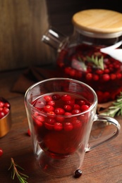Photo of Tasty hot cranberry tea on wooden table