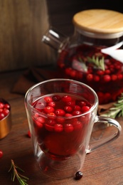 Tasty hot cranberry tea on wooden table