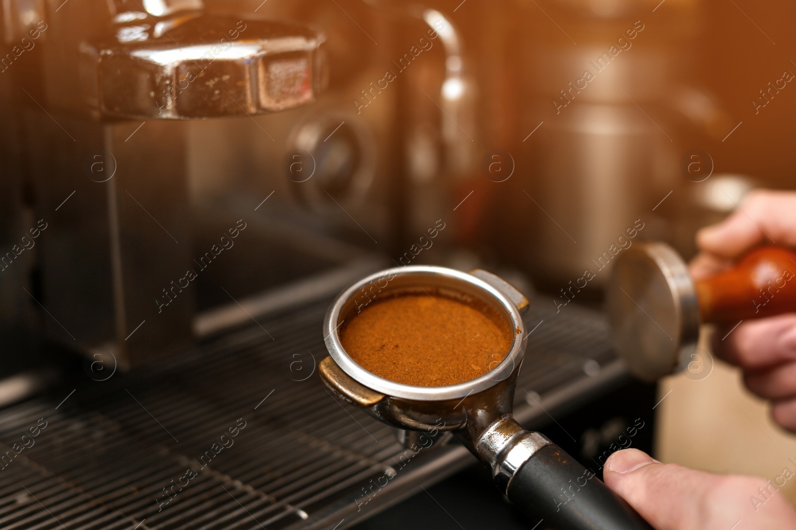 Photo of Male barista making espresso using professional coffee machine, closeup