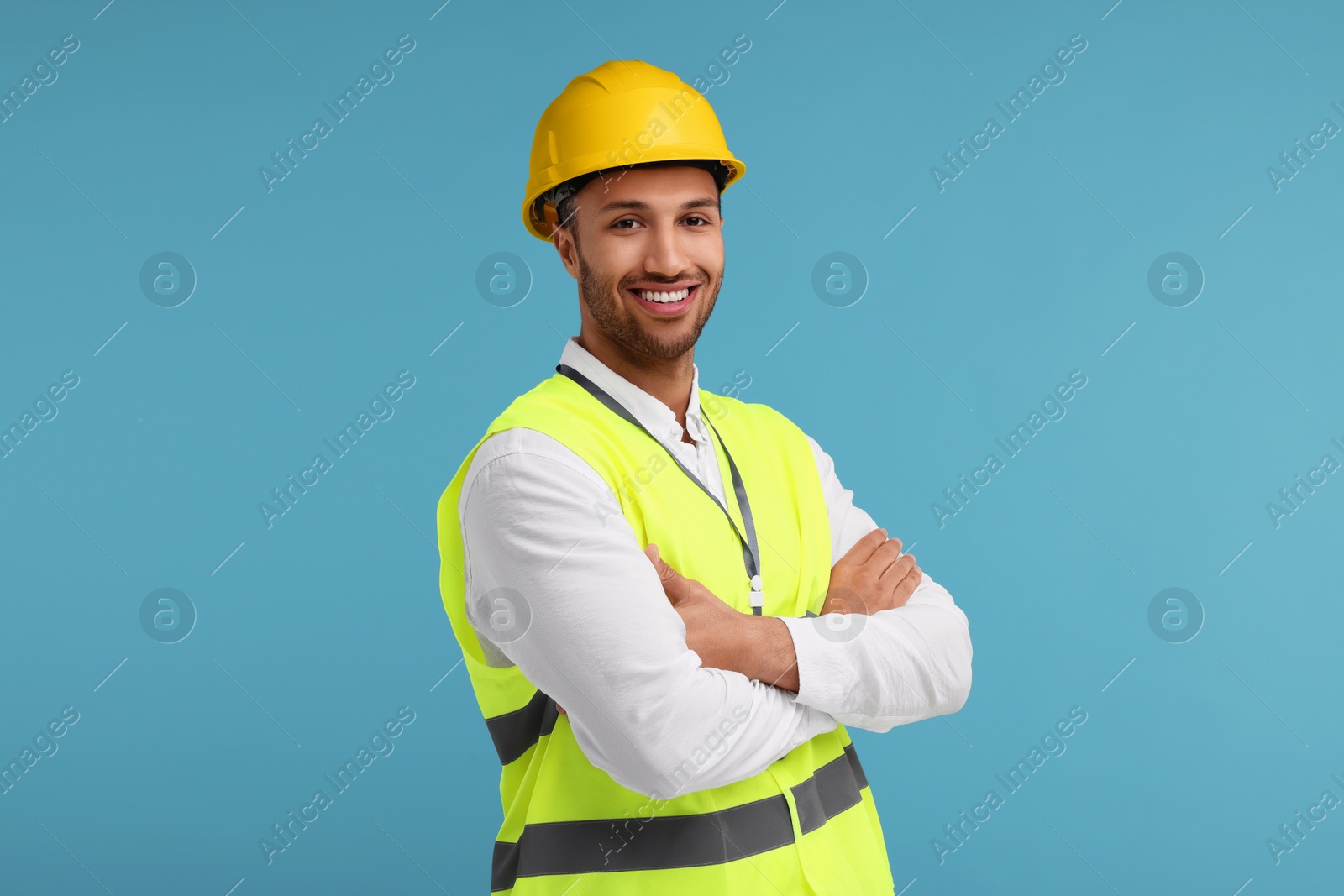 Photo of Engineer in hard hat on light blue background