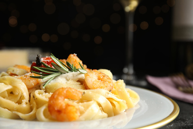 Delicious pasta with shrimps on black background, closeup