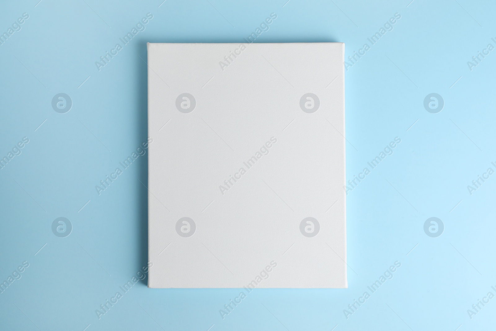 Photo of Blank canvas on light blue background, space for text