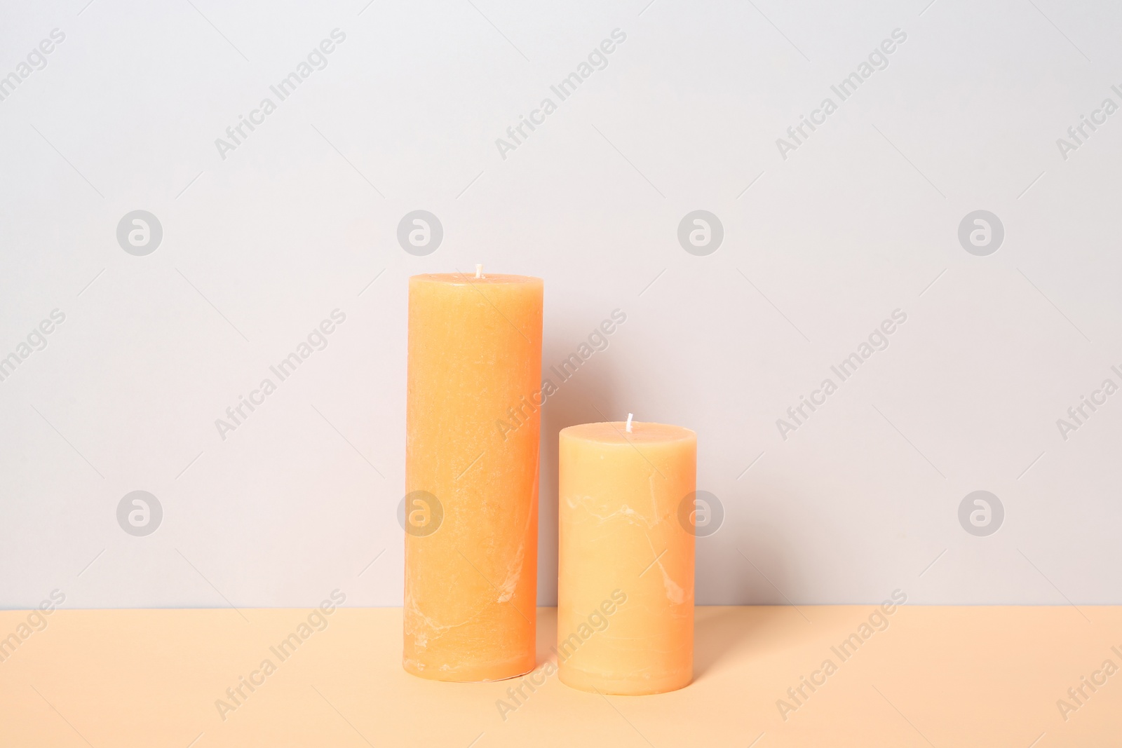 Photo of Decorative candles on table against light background