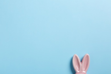 Photo of Easter bunny ears on color background, top view. Space for text