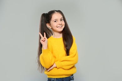 Photo of Portrait of little girl posing on grey background