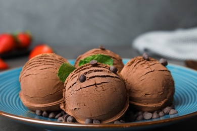 Photo of Plate of chocolate ice cream with mint on grey table, closeup. Space for text