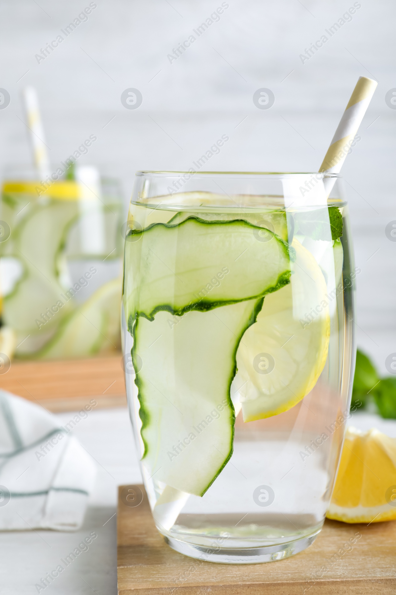 Photo of Refreshing water with cucumber, lemon and mint on white table, closeup